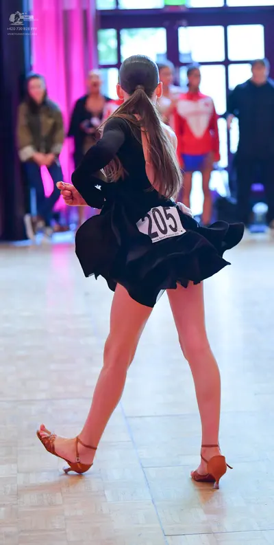 Dancesport competitor #205: Female dancer: black, long-sleeved latin dress with a flared skirt and brown dan