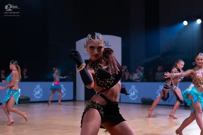 Dancesport competitor: Female dancer (center): black Latin dance costume with heavy sequin and crystal 