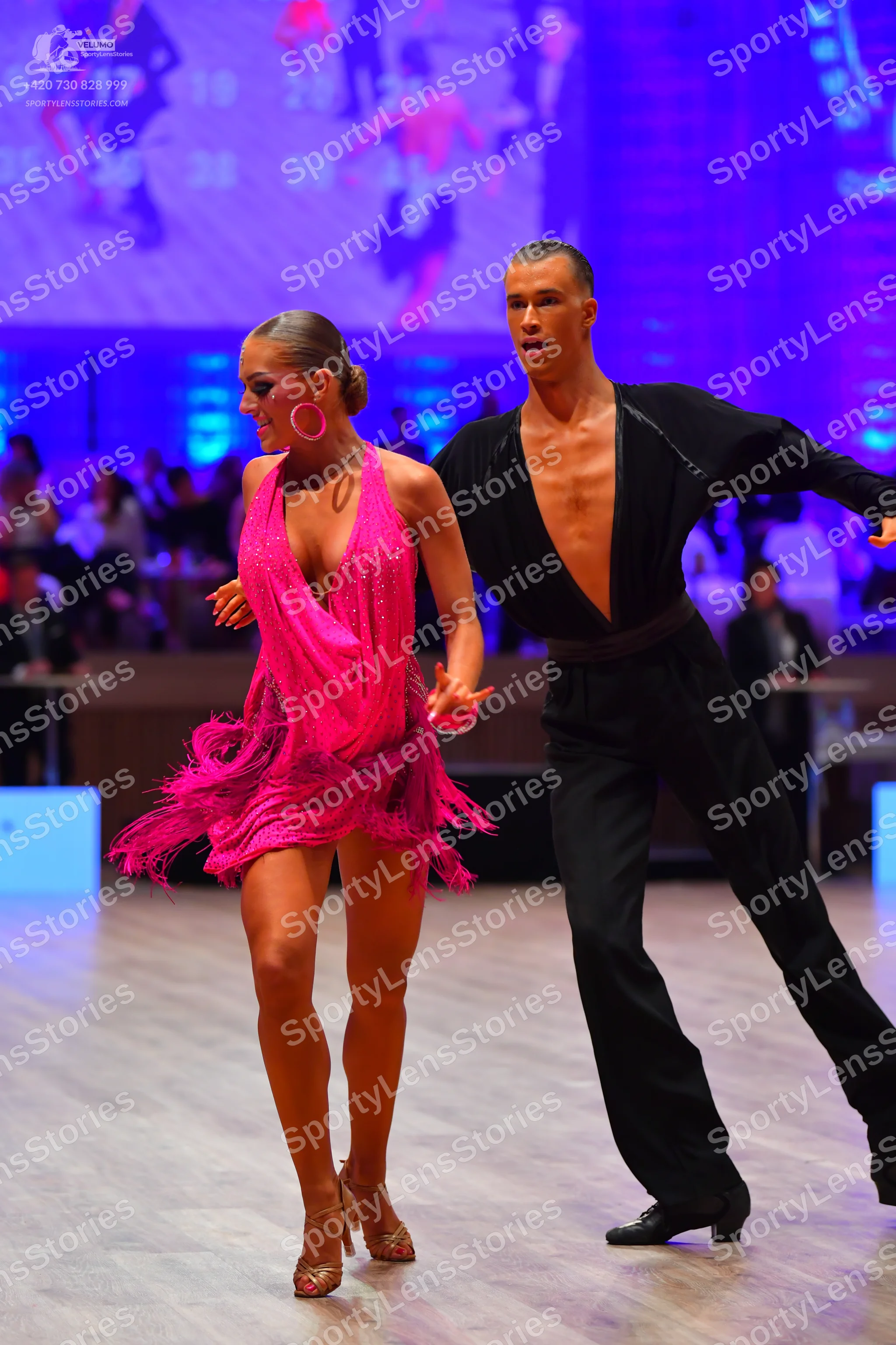 Dancesport competitor: Female dancer: bright pink latin dress with sequins on the bodice and fringe at