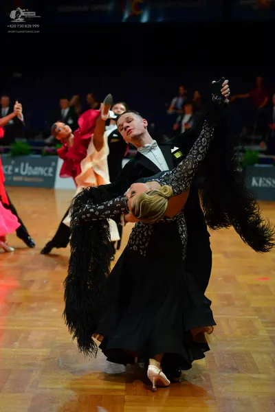 Dancesport competitor: Male dancer: black suit with a white shirt and white bowtie