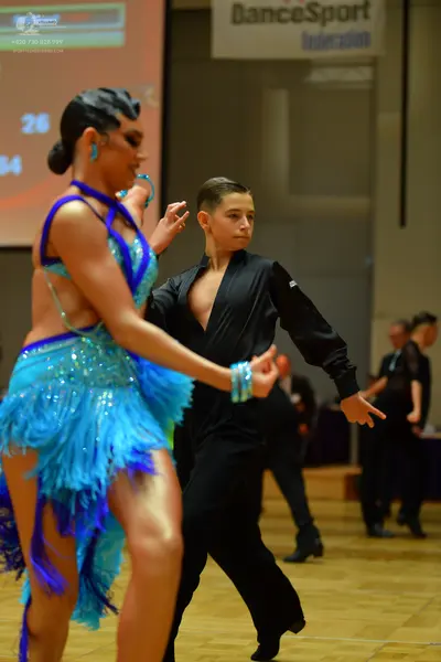 Dancesport competitor: Female dancer: Light blue and dark blue Latin dance dress with heavy sequin embe