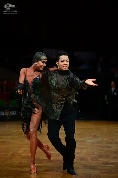 Dancesport competitor: Female dancer: dark green/black sequined latin dress with fringe and a matching 