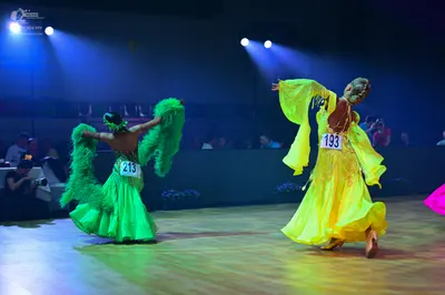 Dancesport competitor: Dancer 1: bright green ballgown with large, fluffy green feather-like accents on