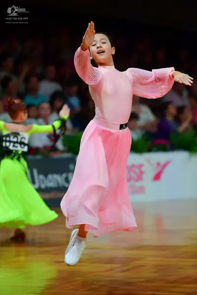 Dancesport competitor: Female dancer (left): neon green latin dress with black patterns