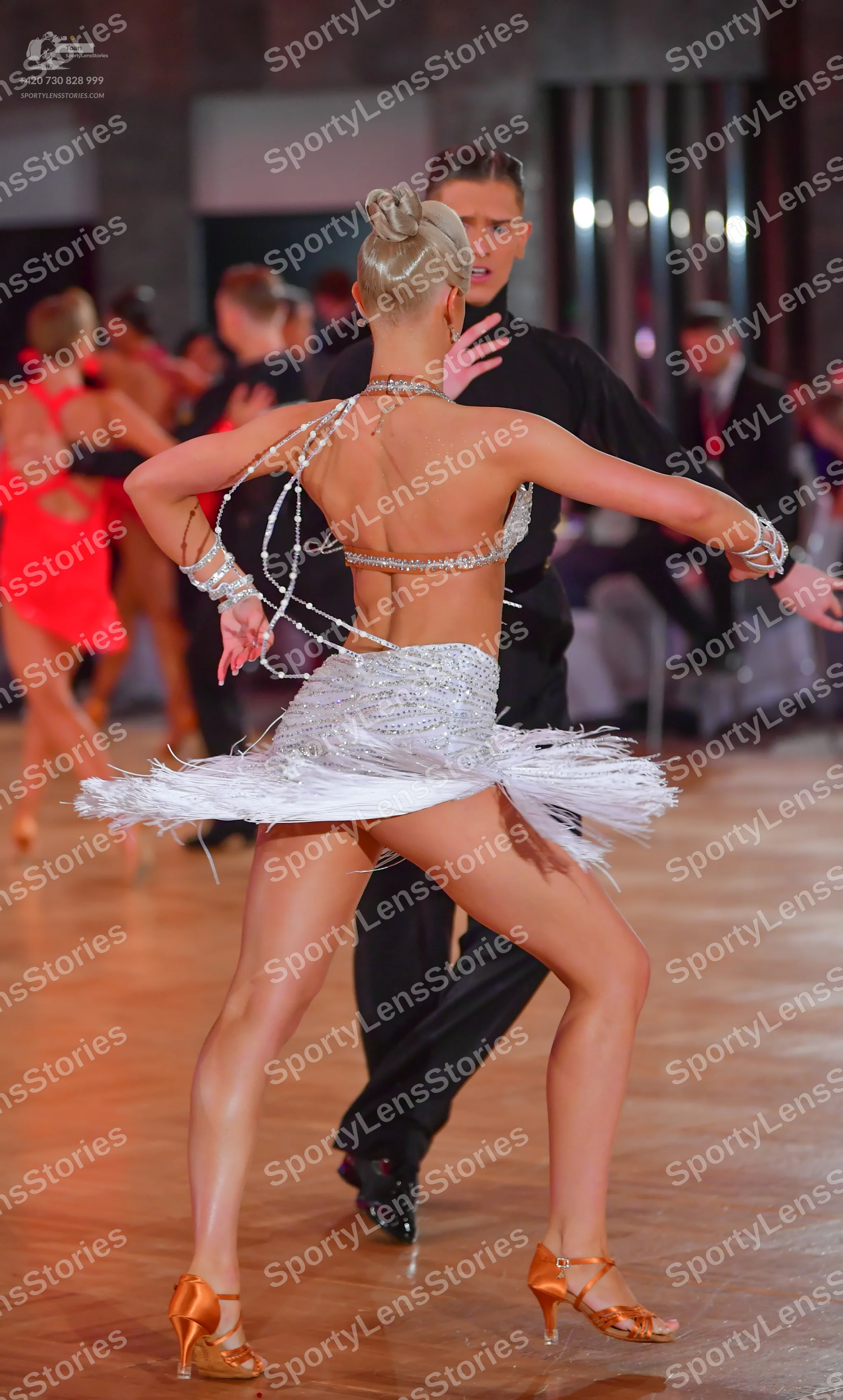 Dancesport competitor: Female dancer: white Latin dance costume featuring a sequined/beaded bra-style t