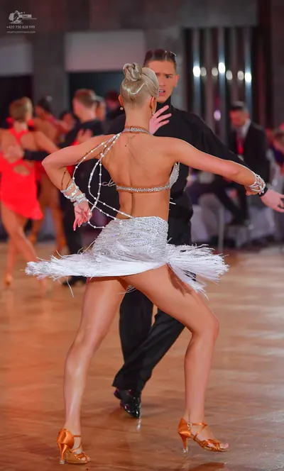 Dancesport competitor: Female dancer: white Latin dance costume featuring a sequined/beaded bra-style t