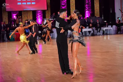 Dancesport competitor #66: Male dancer in foreground: black long-sleeved top and black trousers