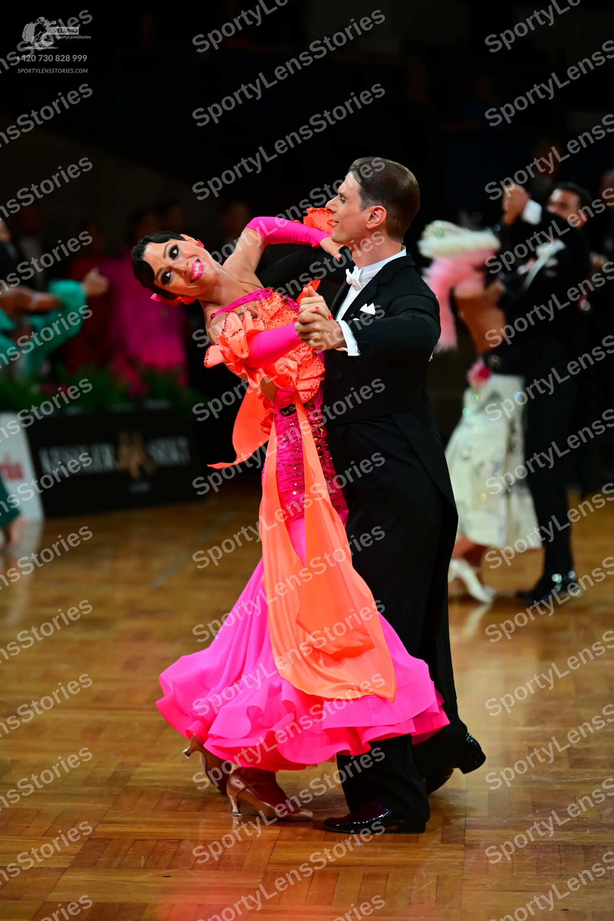 Dancesport competitor: Main female dancer: pink and orange ballroom dress with a sequined bodice and a