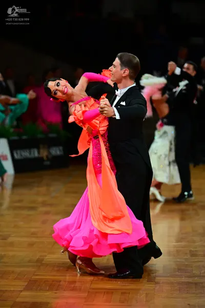 Dancesport competitor: Main female dancer: pink and orange ballroom dress with a sequined bodice and a 