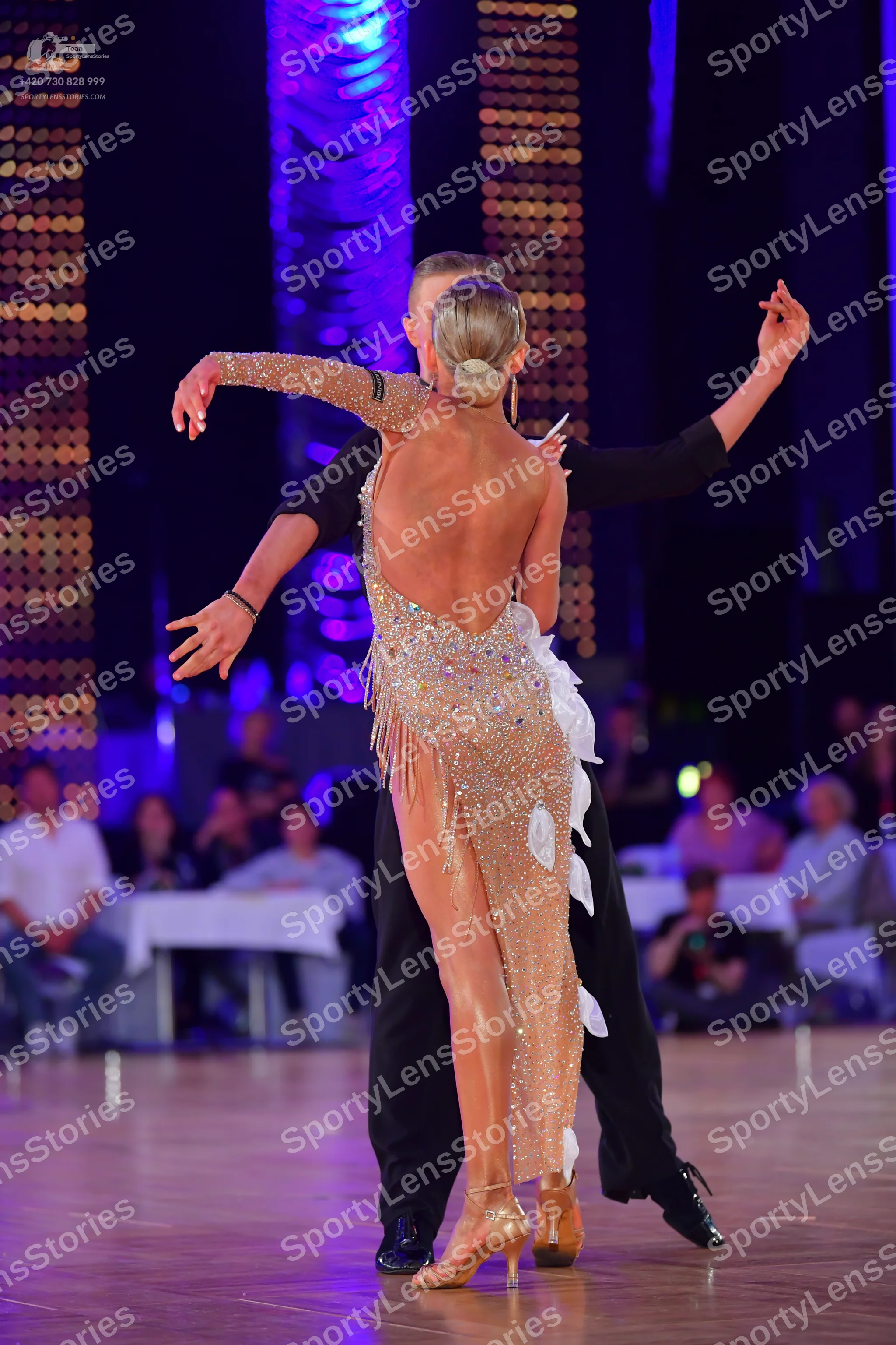 Dancesport competitor: Female dancer: champagne-colored, backless, sequined Latin dress with a high sli