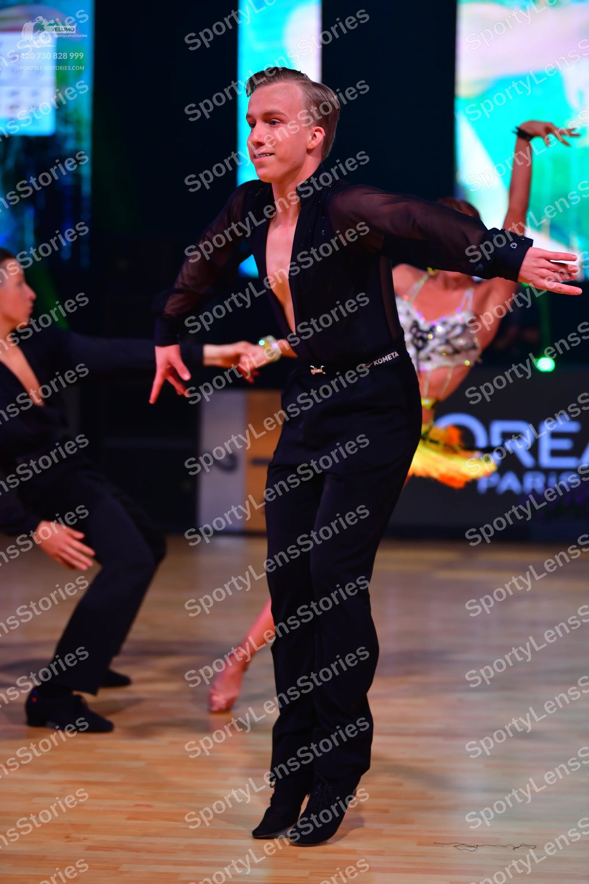 Dancesport competitor: Male dancer 1: black long-sleeved shirt with sheer sleeves and black trousers