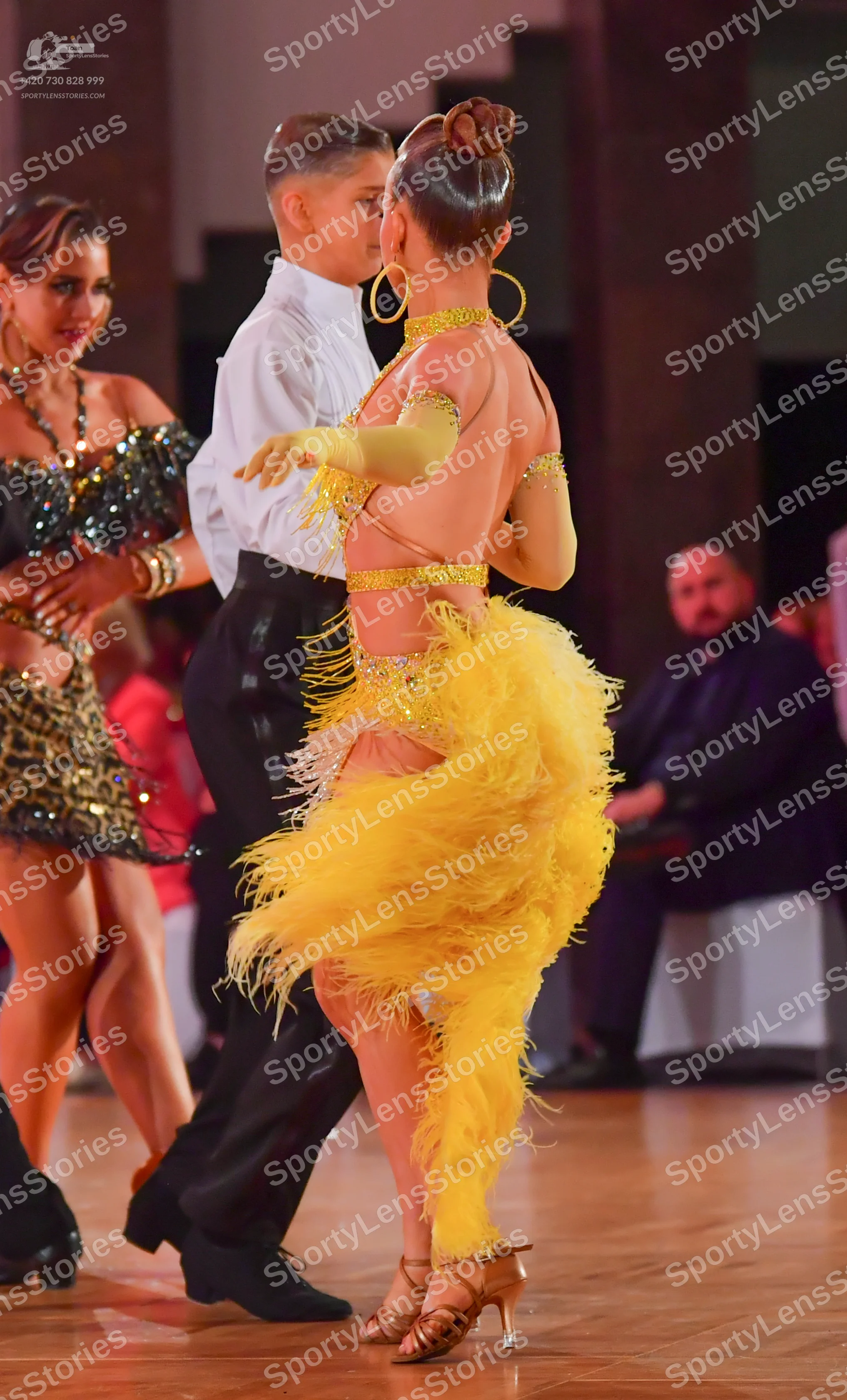 Dancesport competitor: Female dancer: black sequin latin dress with gold bracelets