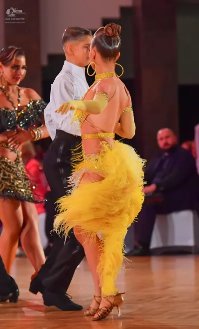 Dancesport competitor: Female dancer: black sequin latin dress with gold bracelets