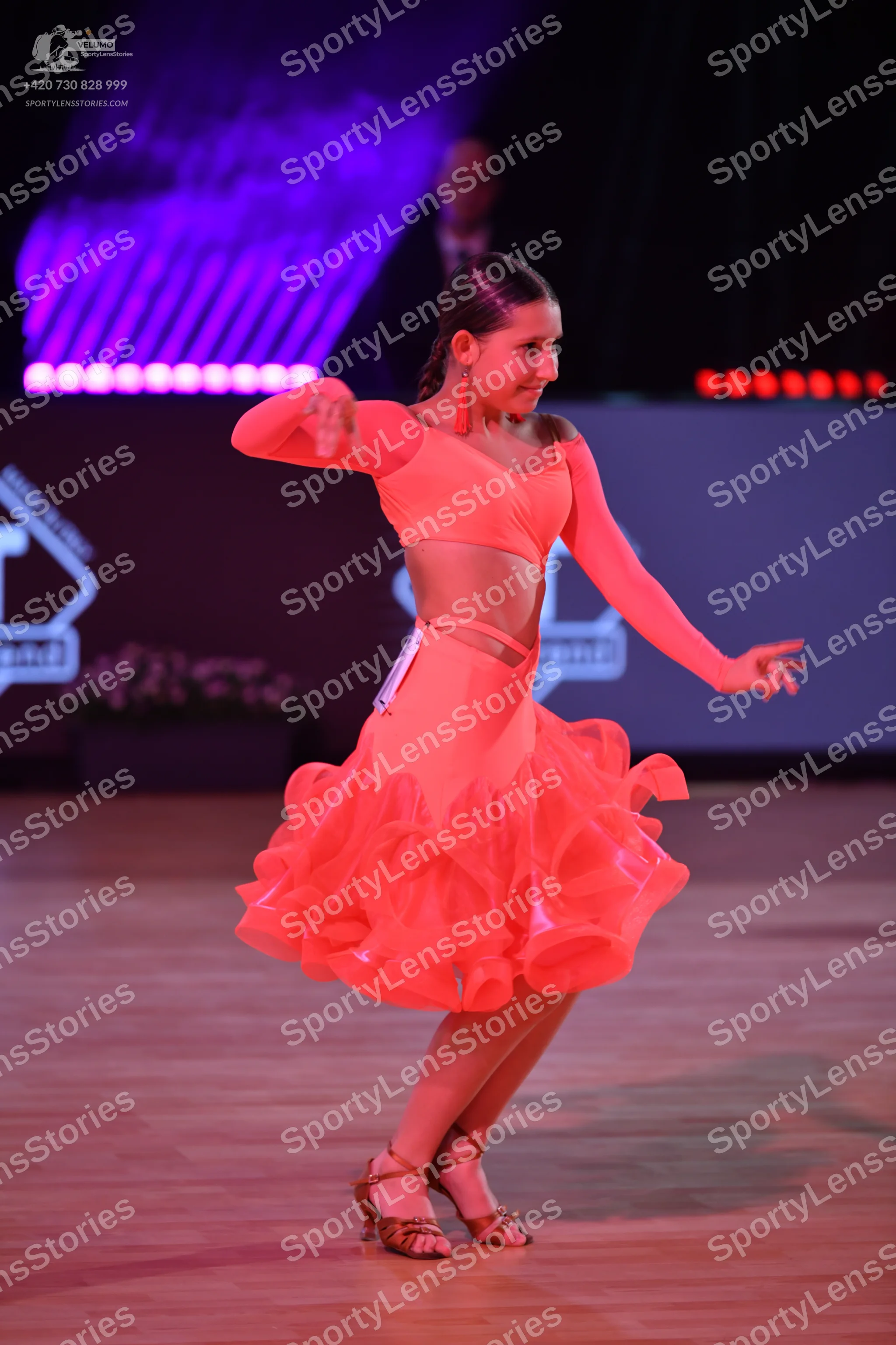 Dancesport competitor: Female dancer: peach-colored Latin dance dress with long sleeves, a cropped bodi