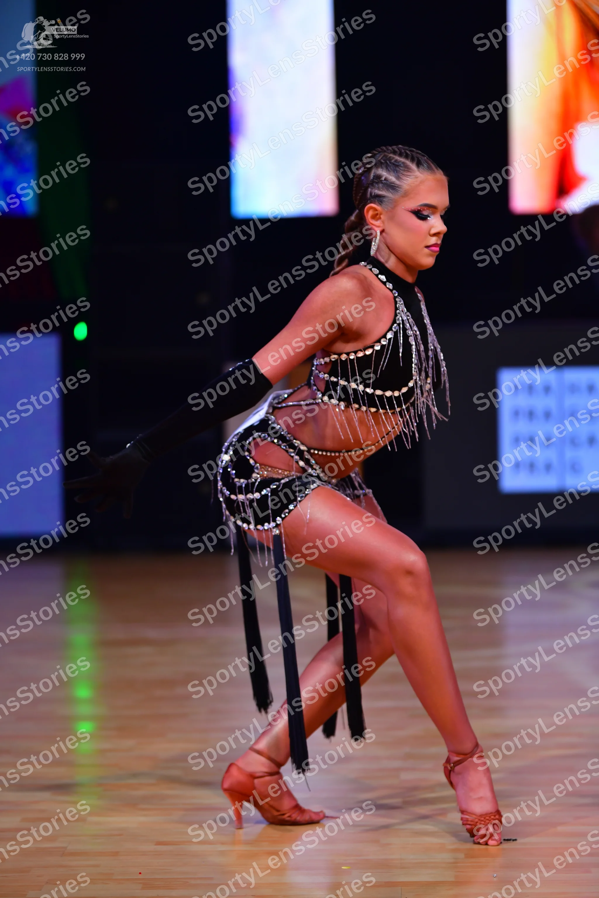 Dancesport competitor: Female dancer: black Latin dance costume featuring silver crystal embellishments