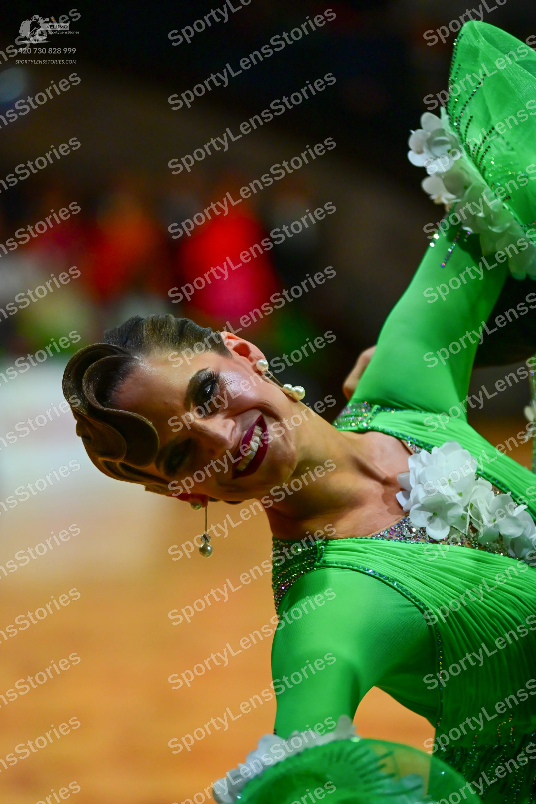 Dancesport competitor: Female dancer: bright green long-sleeved Latin dance dress with ribbed fabric, w
