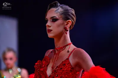 Dancesport competitor: Female dancer (foreground): red latin dress with sequins, 3D floral embellishmen