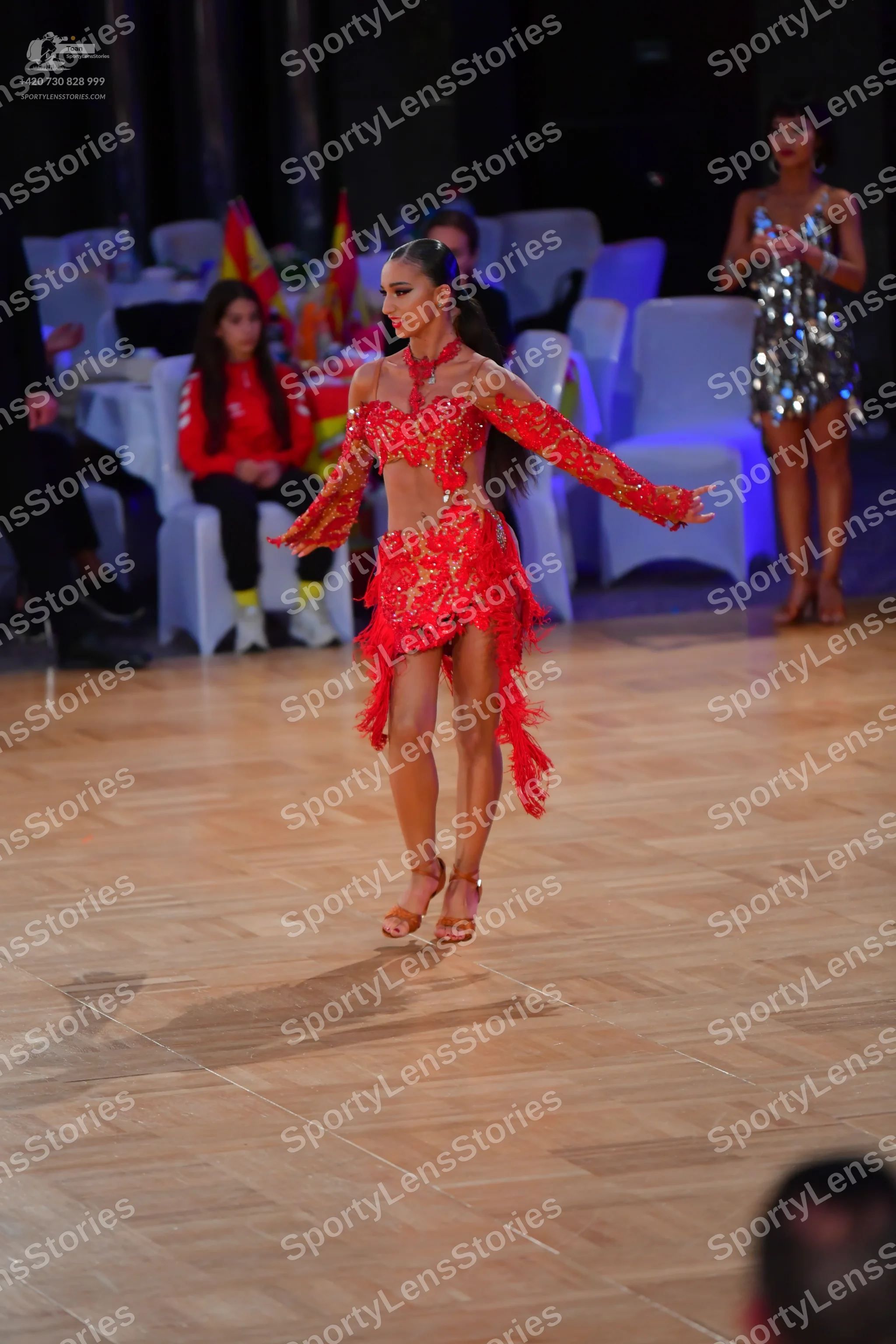 Dancesport competitor: Female dancer: red latin dress with lace and sheer mesh panels