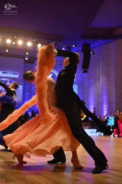 Dancesport competitor: Female dancer: peach-colored ballroom dress with a voluminous flowing skirt and 