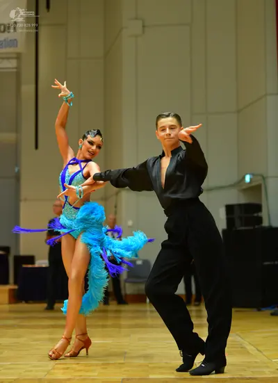 Dancesport competitor: Male dancer: black long-sleeved shirt with a deep neckline and black trousers