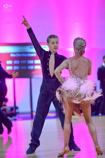 Dancesport competitor: Male dancer: black long-sleeved shirt with a deep V-neckline and buttons, black 