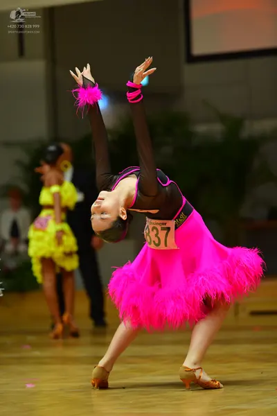 Dancesport competitor #837: Foreground female dancer: bright pink Latin dress with a black bodice and a volu