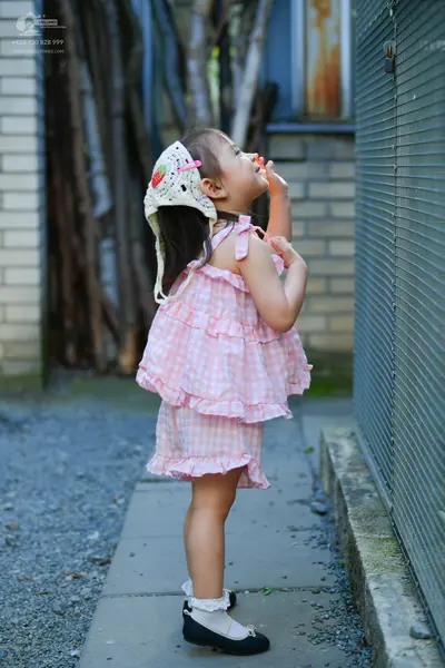 Dancesport competitor: Female dancer: pink and white gingham ruffled dress with thin straps, a white su