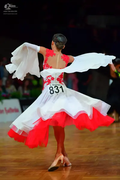 Dancesport competitor: Female dancer: red lace bodice, voluminous white skirt with a red underskirt, an