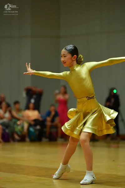 Dancesport competitor: Female dancer: gold-colored satin, long-sleeved dress with a high neck and a fla