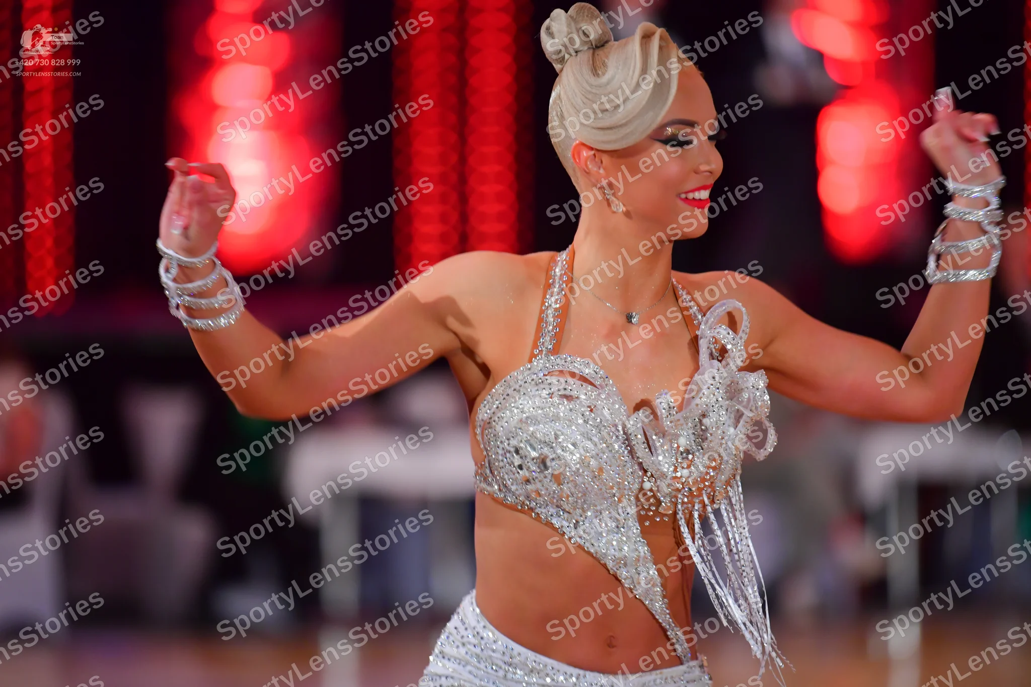 Dancesport competitor: Female dancer: silver two-piece Latin costume heavily embellished with sequins a