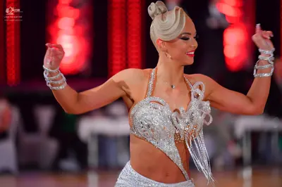 Dancesport competitor: Female dancer: silver two-piece Latin costume heavily embellished with sequins a