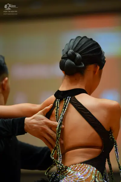 Dancesport competitor: Female dancer: black Latin dress with a velvet-like halter neck, an open back wi