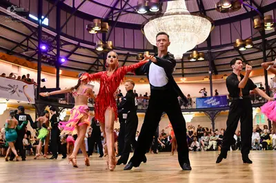 Dancesport competitor #141, #149: Female dancer in red: red latin dress with fringe