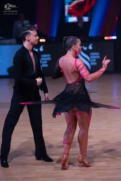 Dancesport competitor: Male dancer: black long-sleeved shirt with a deep V-neck and black trousers