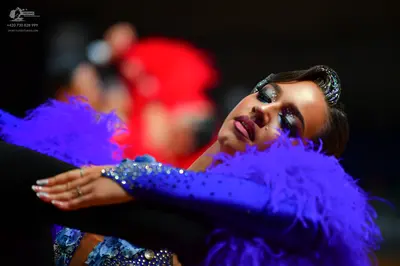 Dancesport competitor: Female dancer: blue/periwinkle long-sleeved Latin dress with sequins, rhinestone
