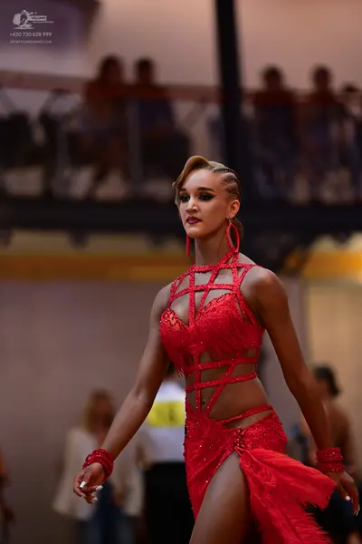 Dancesport competitor: Female dancer: red latin dress with sequins and cutouts
