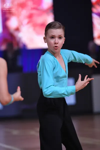 Dancesport competitor: Male dancer: light blue long-sleeved V-neck top and black trousers