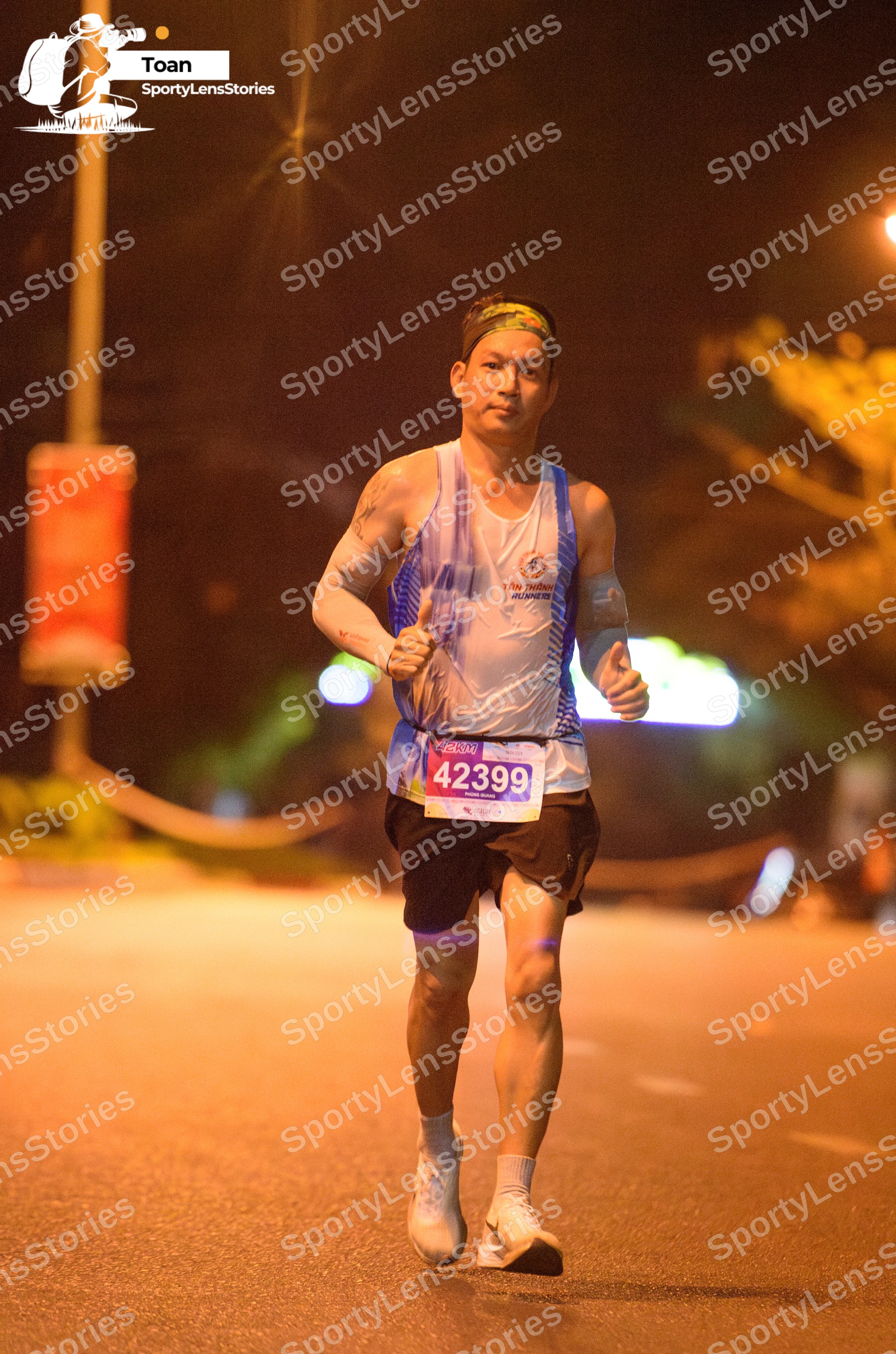 Marathon runner #42399: Runner 1: white and blue tank top, black shorts, white socks, white shoes, and a
