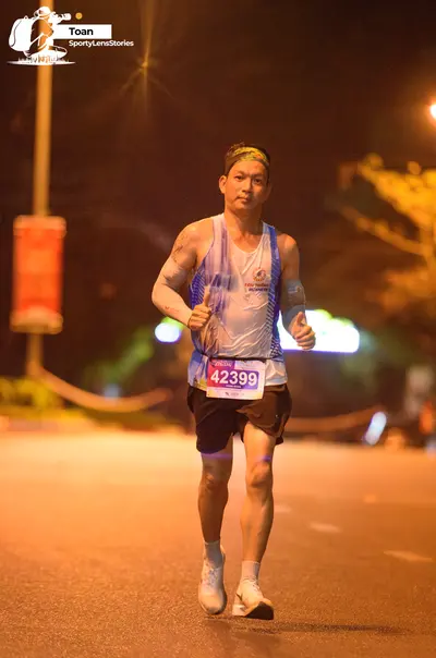 Marathon runner #42399: Runner 1: white and blue tank top, black shorts, white socks, white shoes, and a