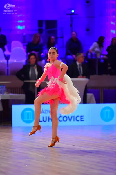 Dancesport competitor: Female dancer: pink Latin dress with white feathery trim