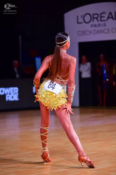 Dancesport competitor: Female dancer: yellow sequined latin costume with thin straps and matching gold-