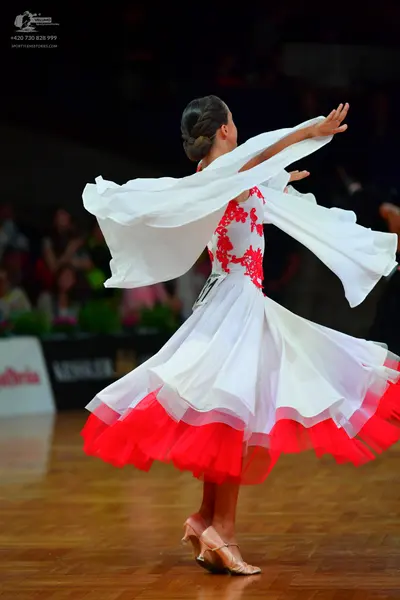 Dancesport competitor: Female dancer: white ballroom dress with red lace embroidery on the bodice and a
