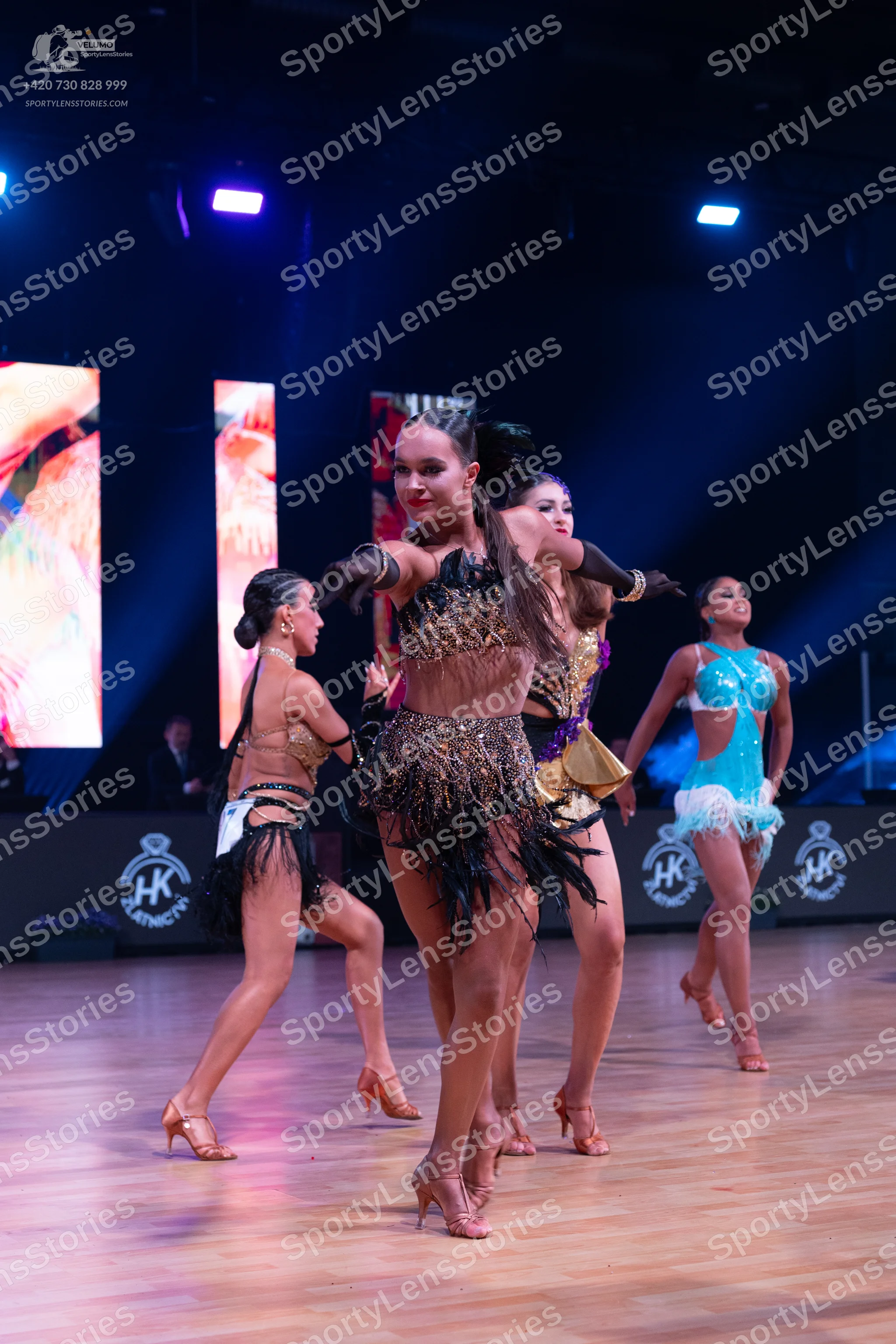Dancesport competitor: Dancer on left: brown latin dress with sequin bodice, black fringe, and a dark w