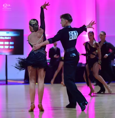 Dancesport competitor #617: Male dancer (foreground): black long-sleeved dance shirt and black trousers