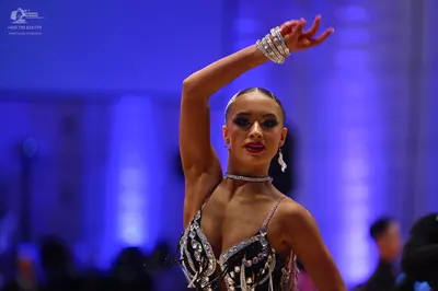 Dancesport competitor: Female dancer: black latin dance top with silver sequins and rhinestones, featur