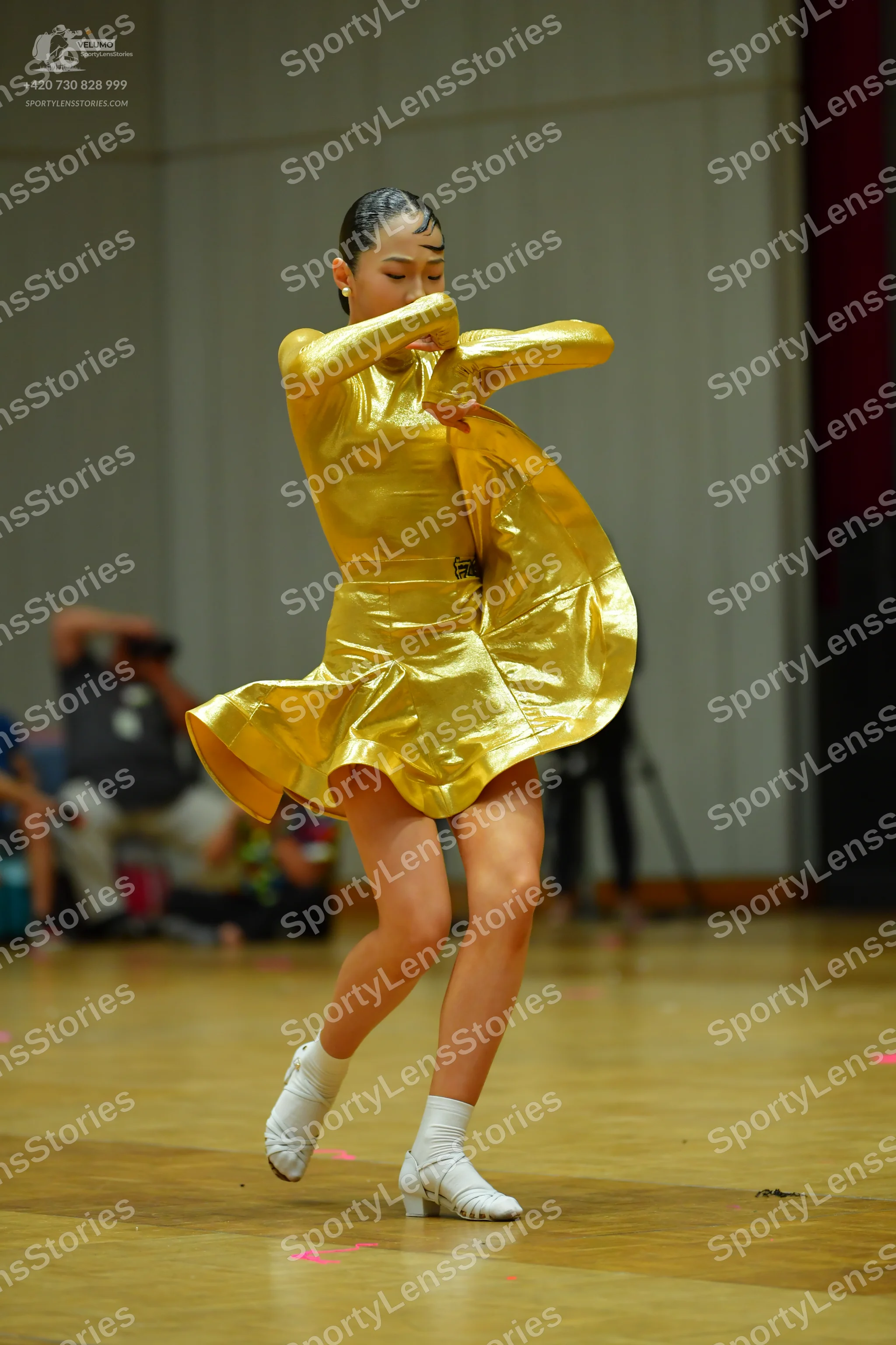 Dancesport competitor: Female dancer: metallic gold long-sleeved latin dress with a flared skirt