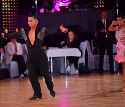 Dancesport competitor: Male dancer: black long-sleeved shirt with silver sequin patterns on the shoulde