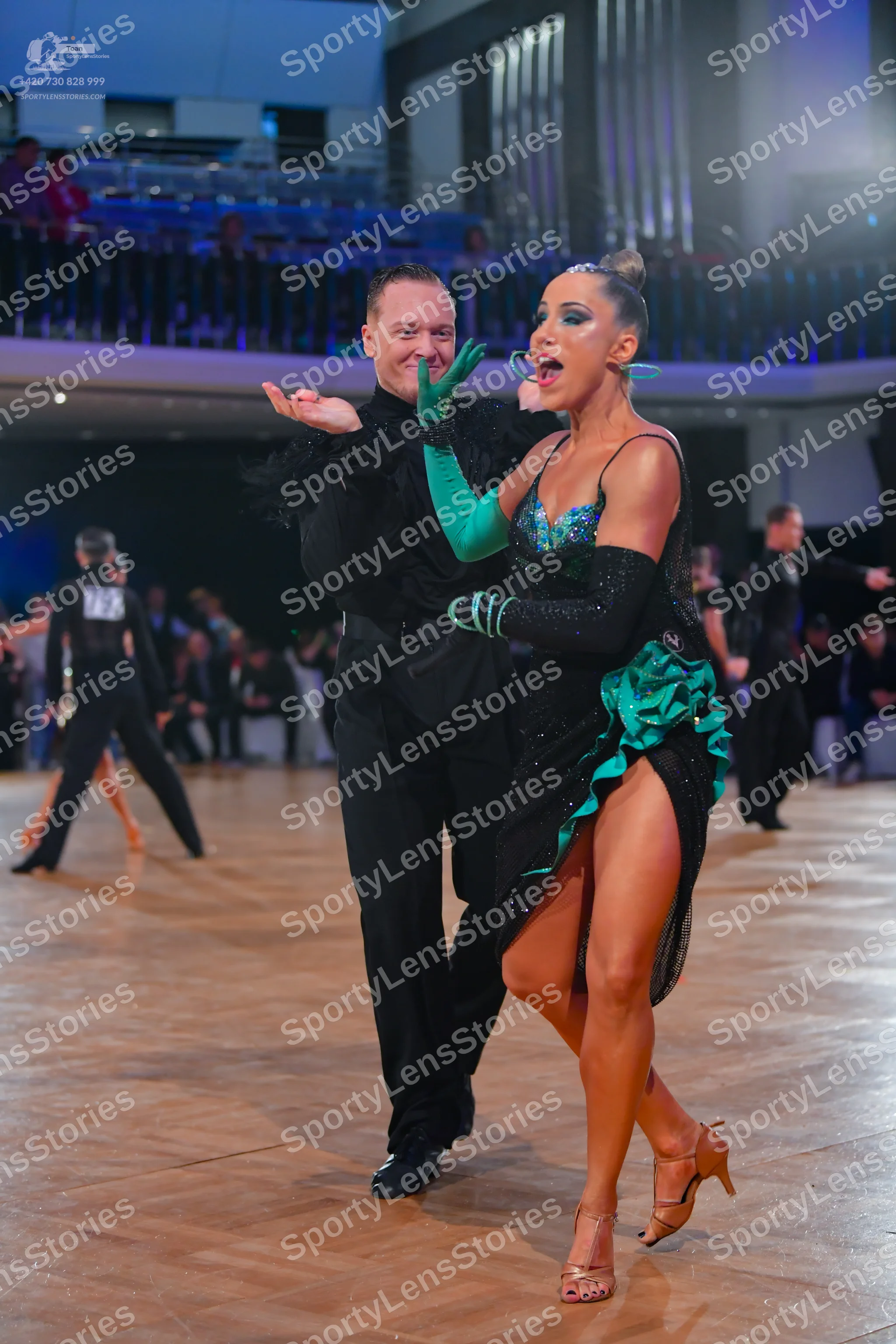 Dancesport competitor #213: Main female dancer: black latin dress with a teal sequined bodice and teal ruffl