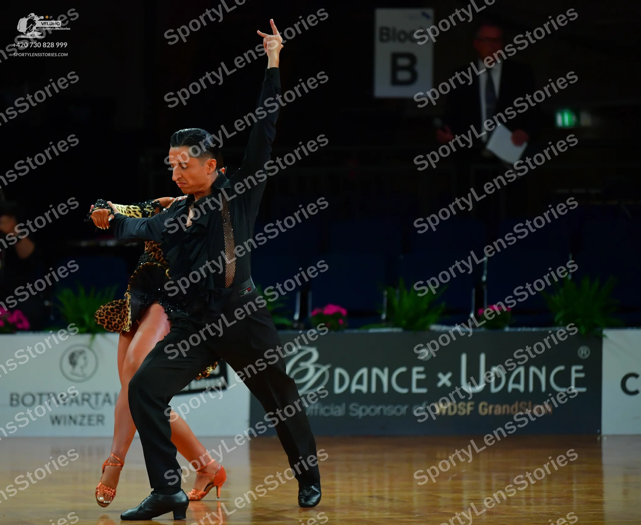 Dancesport competitor: Male dancer: black long-sleeved shirt with textured/metallic detailing, black tr