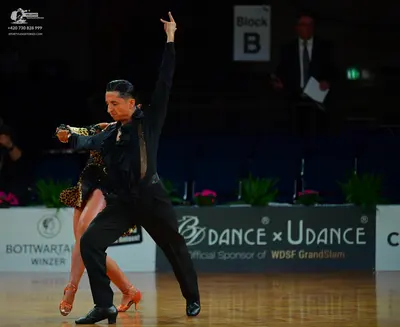 Dancesport competitor: Male dancer: black long-sleeved shirt with textured/metallic detailing, black tr